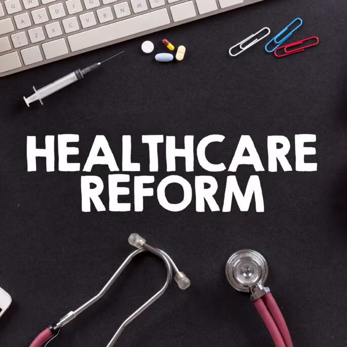 desktop covered in medical tools and text that says healthcare reform