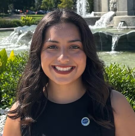 Person outside in front of a fountain